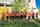 Des personnes portant des t-shirts orange debout devant une rangée d'arbres. À l'avant-plan, on voit des herbes hautes. Sur les t-shirts, de petites empreintes de main sont regroupées en forme de cœur avec le numéro 215+ au-dessus.