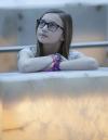 Three young people leaning on a glowing alabaster ramp and looking up.