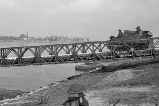 Un véhicule blindé traversant un pont temporaire qui enjambe un plan d’eau.