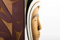 Un plan rapproché d'une boîte sculptée, où on voit le visage une personne contre un fond blanc.