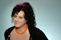 A smiling woman with her arms extended behind her 