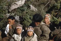 Un groupe de femmes et d’enfants assis. Les deux enfants en avant regarde vers l’objectif.