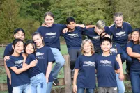 Un groupe de jeunes dehors sur une clôture en bois et posant pour la photo; ils s’embrassent les uns les autres.