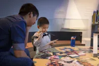 Un enfant et un adulte qui regardent une photographie.