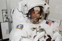Un homme souriant dans un uniforme d'astronaute.