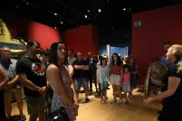 Des personnes debout qui écoutent une guide-interprète du Musée.