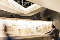 Une foule de personnes marche le long de rampes lumineuses. Certaines personnes prennent des photographies.