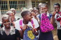 Des filles tiennent des sacs pour produits menstruels de leur atelier de couture de Days for Girls.