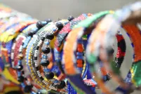 Un étalage de bracelets en perles colorés est présenté à la vente.
