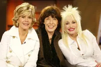 Jane Fonda, Lily Tomlin et Dolly Parton assises ensemble sur un divan.