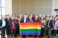  Vingt-huit membres du conseil d’ administration du Fonds Purge LGBT et du Comité consultatif du Monument national LGBTQ2+ posant ensemble et tenant un drapeau arc-en-ciel, lors de la première session de visualisation du Monument en 2019.