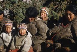 Un groupe de femmes et d’enfants assis. Les deux enfants en avant regarde vers l’objectif.