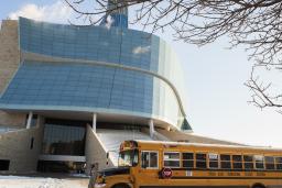 Un autobus scolaire jaune est stationné devant le Musée. 