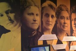 Large photographs of five women on the wall of a Museum exhibit. They are the "Famous Five" - Nellie McLung, Emily Murphy, Irene Parlby, Louise McKinney and Henrietta Edwards. 