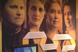 Large photographs of five women on the wall of a Museum exhibit. They are the "Famous Five" - Nellie McLung, Emily Murphy, Irene Parlby, Louise McKinney and Henrietta Edwards. 