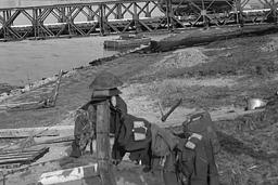 Un véhicule blindé traversant un pont temporaire qui enjambe un plan d’eau.