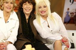 Jane Fonda, Lily Tomlin and Dolly Parton sitting on a couch together.