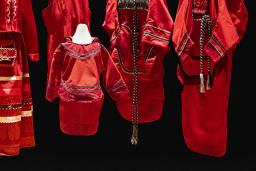 5 red dresses of different sizes and designs are displayed on mannequins.