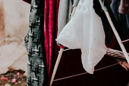 Garments are hung over a rack to air dry. The fabrics are grey, black, white and shocking pink.