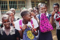 Des filles tiennent des sacs pour produits menstruels de leur atelier de couture de Days for Girls.