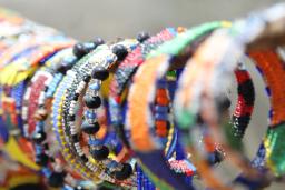 Un étalage de bracelets en perles colorés est présenté à la vente.