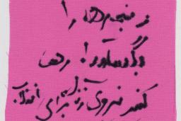 A piece of cloth with "Break the shackles, free woman power for revolution" in Farsi.