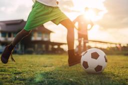 Soccer player on field getting ready to kick the ball.