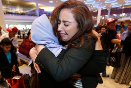 Une femme enlace sa tante à son arrivée à l'aéroport de Winnipeg.