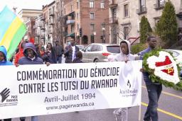 Un groupe de personnes marchant dans la rue avec un bannière sur laquelle on peut lire « Commémoration du génocide contre les Tutsi du Rwanda. Avril-Juillet 1994. www.pagerwanda.ca ».