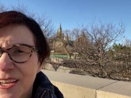 Une femme regardant vers la caméra, avec le centre-ville d'Ottawa visible derrière elle.