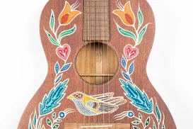Une guitare acoustique décorée de motifs peints.