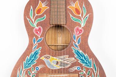 Une guitare acoustique décorée de motifs peints.