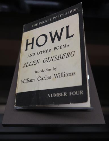 Un livre dans une exposition. Sur la couverture, on peut lire : The Pocket Poets Series. Howl and Other Poems. Allen Ginsberg. Introduction by William Carlos Williams. Number Four. Visibilité masquée.