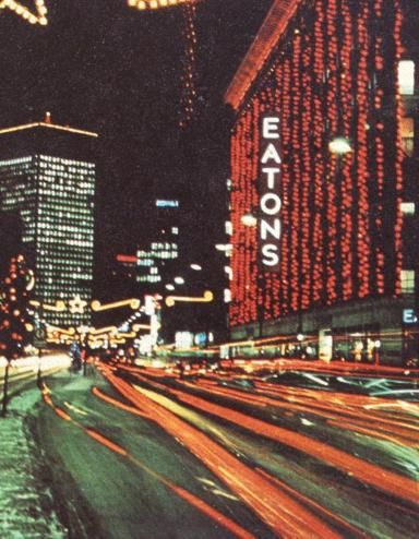 Photo du centre-ville de Winnipeg à la fin des années 1960 où l’on voit l’édifice Eatons décoré de nombreuses lumières de Noël.