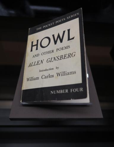 Un livre dans une exposition. Sur la couverture, on peut lire : The Pocket Poets Series. Howl and Other Poems. Allen Ginsberg. Introduction by William Carlos Williams. Number Four.