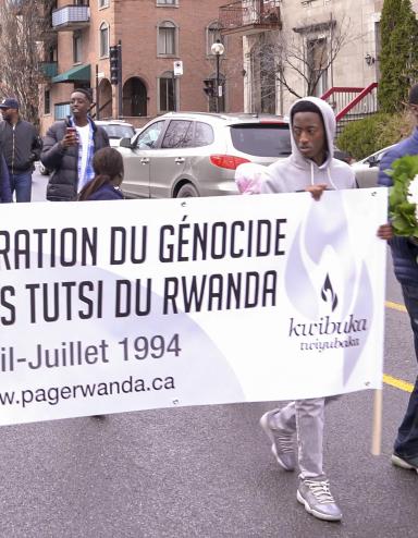 Un groupe de personnes marchant dans la rue avec un bannière sur laquelle on peut lire « Commémoration du génocide contre les Tutsi du Rwanda. Avril-Juillet 1994. www.pagerwanda.ca ».