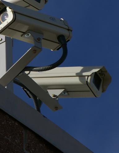 Trois caméras de surveillance sur le coin d'un bâtiment Visibilité masquée.