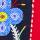 A blue beaded flower on a black and red background.