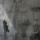 Une image historique translucide d’un homme en complet superposé à une photo contemporaine de deux hommes en silhouette marchant dans un corridor triangulaire.