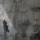 Une image historique translucide d’un homme en complet superposé à une photo contemporaine de deux hommes en silhouette marchant dans un corridor.