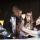 Un groupe d'élèves regardent la surface interactive d'une table qui émet une lumière blanche.