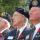 Trois hommes âgés, membres de la Légion canadienne, sont assis côte à côte. Tous les trois portent le coquelicot du jour du Souvenir sur leur uniforme.