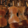 Plusieurs violons restaurés sont présentés appuyés les uns sur les autres dans une pile. Chacun des violons porte au moins une étoile de David.