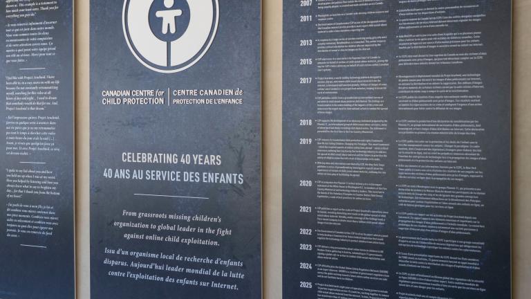 Grands panneaux bleu foncé avec texte et graphiques blancs exposés dans le Corridor communautaire du Musée canadien pour les droits de la personne. Le panneau central comporte un logo circulaire et commémore le 40e anniversaire du Centre canadien de protection de l'enfance. Les deux panneaux de chaque côté présentent du texte bilingue en anglais et en français.
