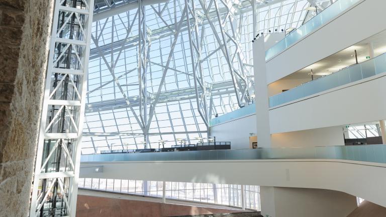 L’intérieur d’un grand espace ouvert du Musée. On voit des panneaux de verre et une terrasse blanche à trois niveaux.