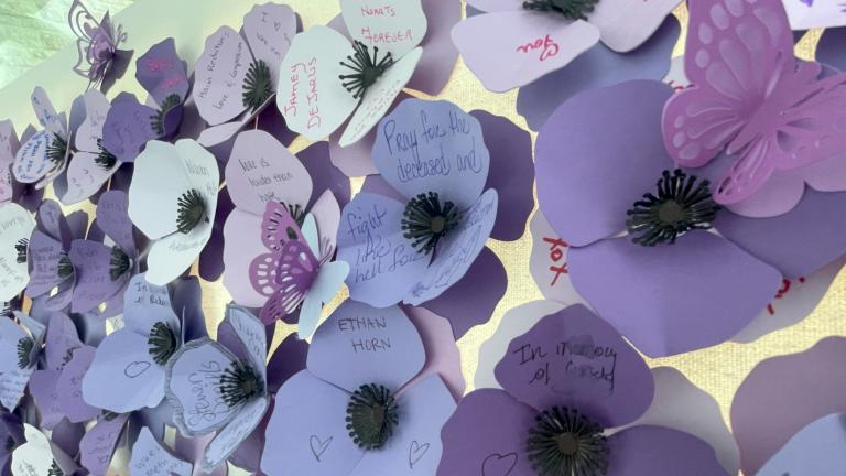 Des pavots violets faits de papier avec des noms et des messages écrits par des membres de la communauté ou de la famille de personne décédées après avoir consommé des drogues empoisonnées. Visibilité masquée.