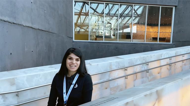 Une femme souriante sur les rampes d'albâtre du Musée. Visibilité masquée.