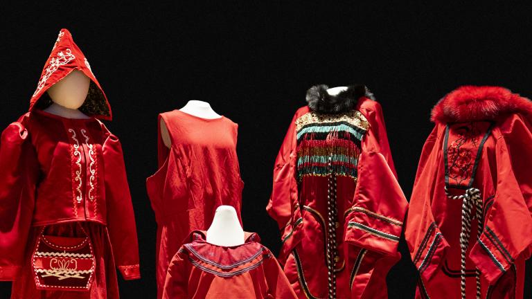 Cinq robes rouges de tailles et de modèles différents sont exposées sur des mannequins. Visibilité masquée.
