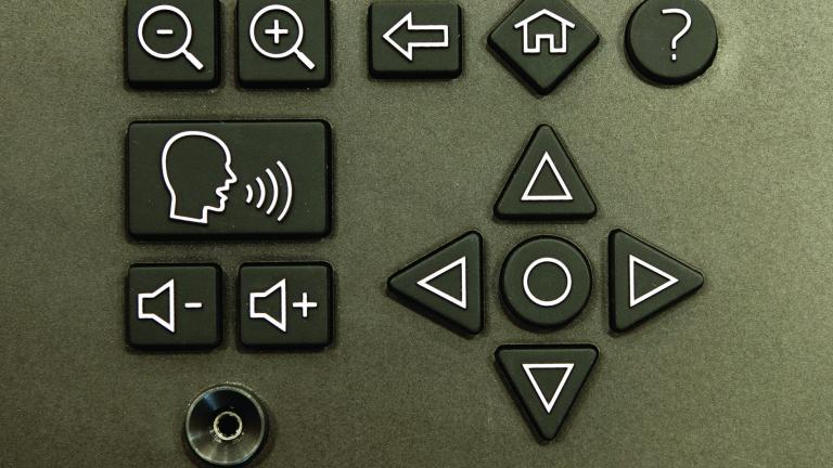 Une prise de type pour écouteurs et un clavier avec des symboles indiquant les commandes de volume, d'agrandissement et de navigation.
