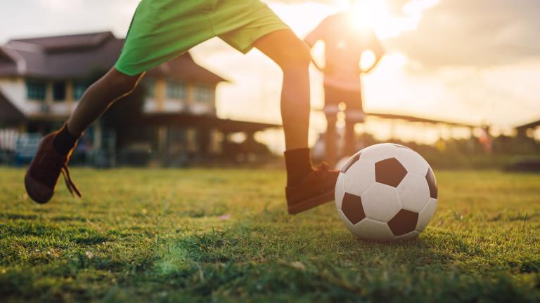Soccer player on field getting ready to kick the ball. Visibilité masquée.